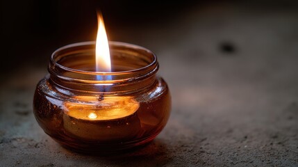 Close-up of a lit candle in a textured ceramic bowl, featuring a steady glowing flame and melted wax surface, creating a warm and calming atmosphere.
