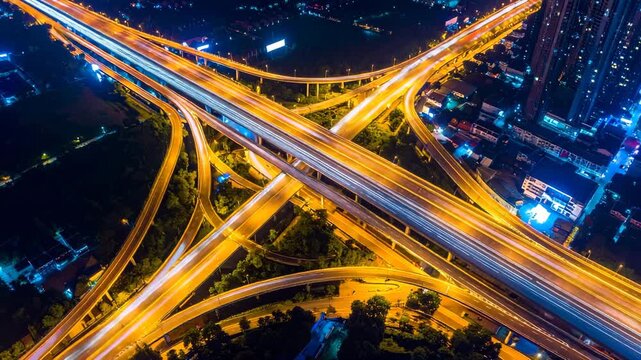 Aerial view of a complex highway intersection, illuminated at night