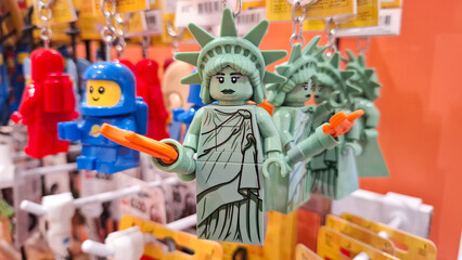 Naklejka premium Collection of LEGO Statue of Liberty and astronaut character bag tags with keychains on retail store display for illustrative editorial use on February 21, 2026 in Bangkok, Thailand