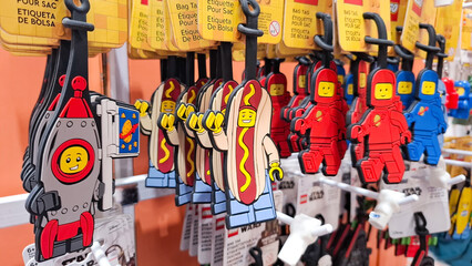 Naklejka premium Collection of colorful LEGO character bag tags and keychains featuring astronaut and hot dog man designs on retail display for illustrative editorial use on February 21, 2026 in Bangkok, Thailand