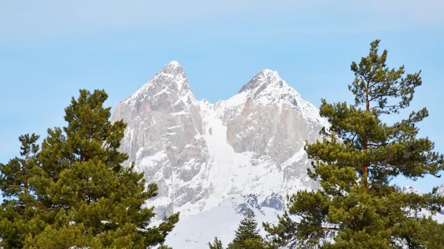 Close up aerial zoom in view Ushba Mountain Svaneti Georgia timelapse with twin peaks above pine forest, clear sky, Caucasus alpine wilderness, adventure travel mood, nature power concept