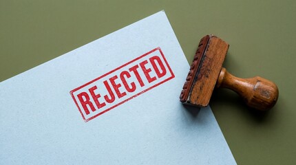 Rejected stamp on document with wooden stamper on green background