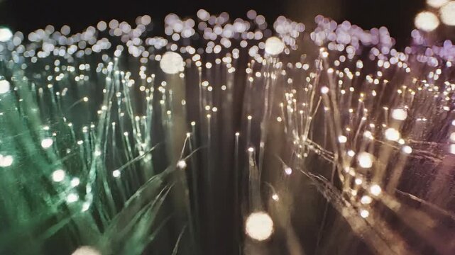 Abstract fiber optic cable network with glowing light particles in green, orange, and purple hues