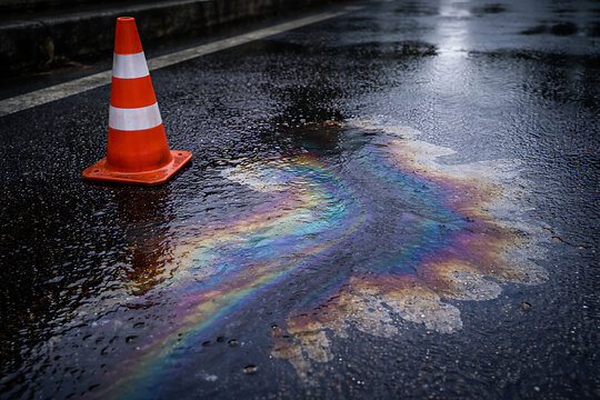 Oil Spill and traffic cone on the road, with rainbow colors