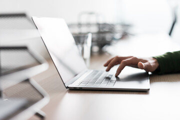 Close up of hand using laptop touchpad on office desk for corporate business marketing digital technology advertisements and remote work.