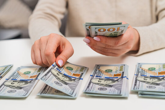 Close up of man counting dollar banknotes and separating them into stacks. Financial control, accounting, business profit and cash flow theme.