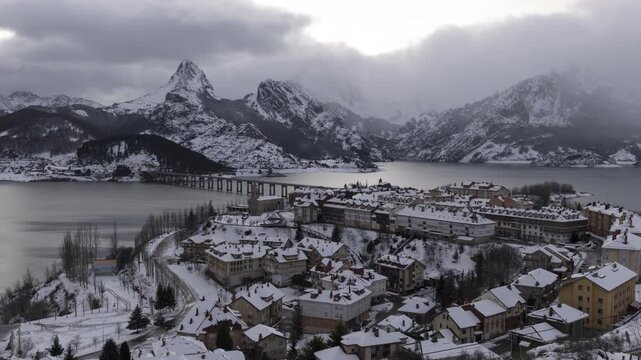 Snowy Village Sunset to Night Time Lapse. A high-angle time lapse of Riano village in the Leon mountains during winter. The footage shows the transition from sunset to night over the snowy landscape