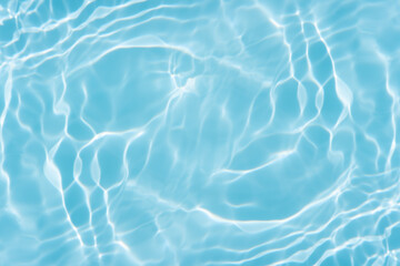 Obraz premium Blue water with ripples on the surface. Defocus blurred transparent blue colored clear calm water surface texture with splashes and bubbles. Water waves with shining pattern texture background.