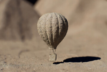 Balloon hot air sandy textured with basket and ropes on sandy ground featuring desert, sand, travel with adventure and exploration elements for transportation, recreation projects, clean composition