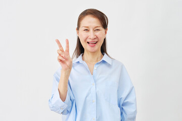 白背景でピースサインをする女性