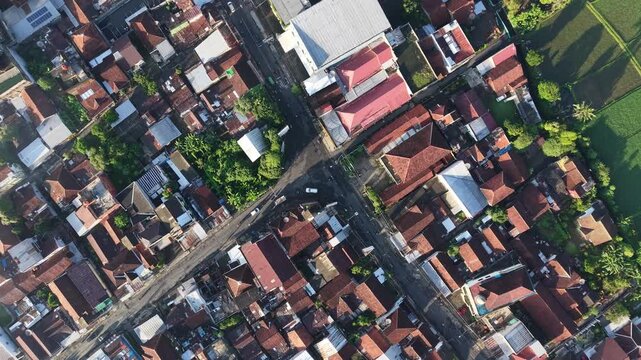 Aerial Drone View of Indonesian Town Rooftops and Road Intersection Near Rice Fields