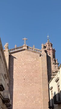 Michoacan Cathedral rear facade from Garcia Obeso Street in Morelia Mexico, historic colonial architecture landmark with stone walls and blue sky in city center
