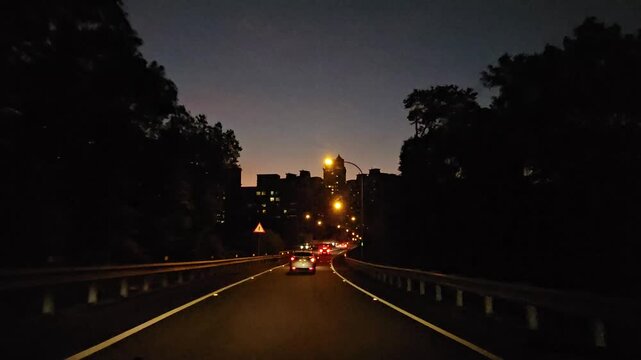 Taipei City, Taiwan - December 07 2025. Driving Night view from the National Freeway No.5 Xindian exit, featuring modern city buildings, glowing streetlights, and a cinematic grainy atmosphere 