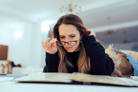 Woman Takes Off Her Glasses to Read the Menu at a Restaurant. Lady looking worried reading the food list to look for possible allergens 