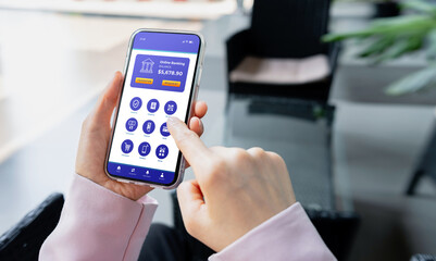 Close-up of a person using a mobile banking application on a smartphone. Concept of digital finance, online banking or cashless payment