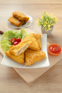 Crispy Triangular Fried Chicken Risoles Ragout with Savory Vegetable Filling Served with Chili Sauce on White Plate