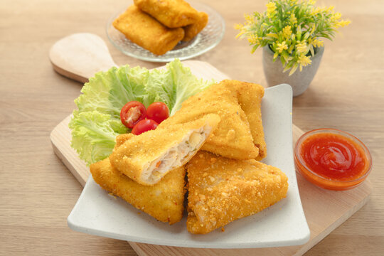 Crispy Triangular Fried Chicken Risoles Ragout with Savory Vegetable Filling Served with Chili Sauce on White Plate