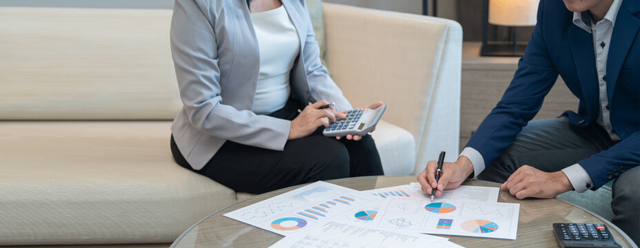 Professional financial advisor discussing personal investment strategy with clients using calcualtor in a modern office, wealth management and retirement planning concept. with copy space.