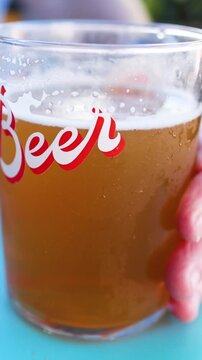 Close Up of a Cold Beer Glass with Red Script Text