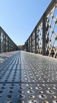 Low Angle Perspective of a Metal Lattice Pedestrian Bridge Walkway