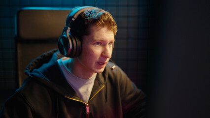 Young teen streamer gamer man play fail online video computer game. Esport concept virtual entertainment. Cyber e sport videogame tournament live stream. Neon light. Tense player loss competition. © Татьяна Епанешникова