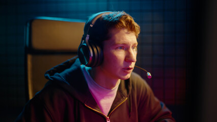 Young teen streamer gamer man play fail online video computer game. Esport concept virtual entertainment. Cyber e sport videogame tournament live stream. Neon light. Tense player loss competition. © Татьяна Епанешникова