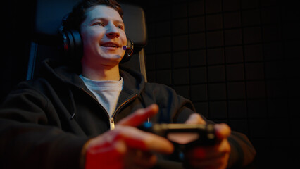 Young teen boy streamer gamer man playing online video game on computer use joystick. Gaming console virtual entertainment. Cyber e sport videogame controller. Neon light. Tense player hold joypad. © Татьяна Епанешникова