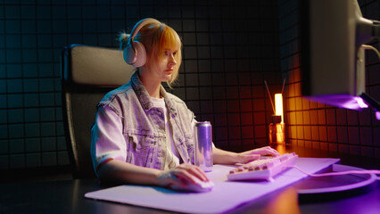 Young teen streamer gamer woman playing online video game on computer. Esport concept gaming virtual entertainment. E sport videogame tournament live stream. Tense female player cool girl competition. © Татьяна Епанешникова