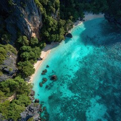 Aerial shot of a secluded beach with turquoise water, cliffs, and lush green vegetation