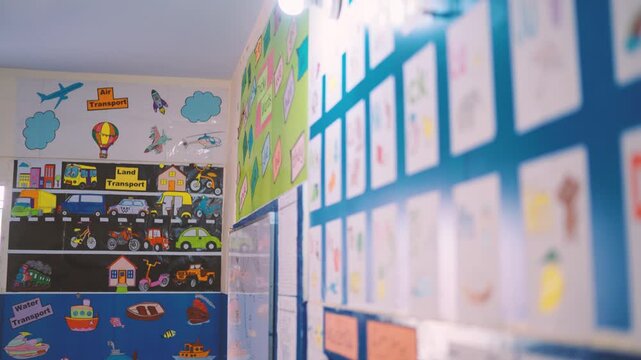 Classroom wall featuring colorful transport charts and children's drawings in a school environment