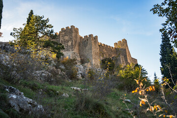 Ancient medieval castle fortress with stone walls and towers on rocky mountain hill.  © Yar