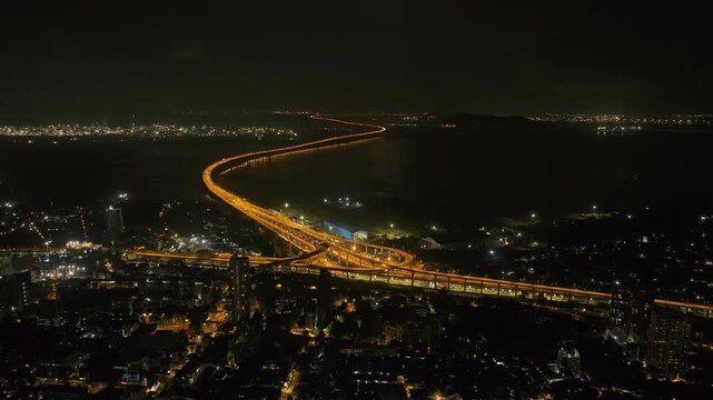 India's Longest Sea Bridge: Trans-Harbour Sea Link. Atal Setu sea bridge in Mumbai, Maharashtra, India. A city at night with bright skyscrapers and a dense network of glowing buildings.