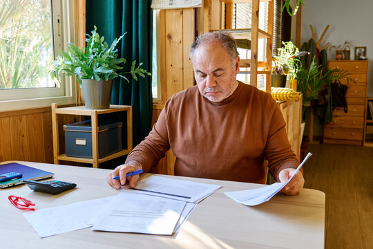 Man reviewing household budget and paperwork at home desk