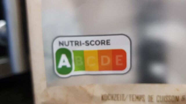 Camera motion approaching until focusing a package of food with A level in the nutri score scale. 
