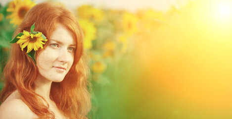 Fototapeta premium Redhead with freckles. Beautiful model in the sunset. Beauty girl. A woman in a flower crown is positioned in a sunflower field.