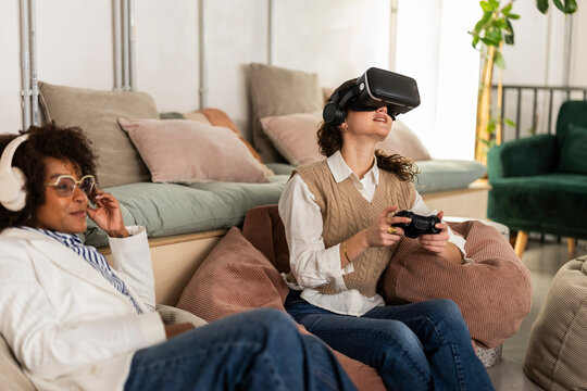 Woman using virtual reality headset and gaming controller in modern office