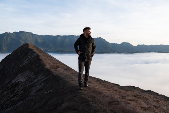 Traveler exploring volcanic ridge at sunrise in Java Indonesia