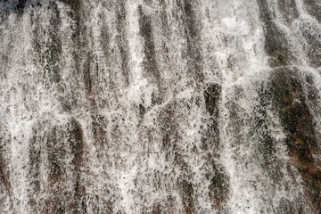 Fototapeta premium Detailed texture of cascading waterfall against rocky cliff