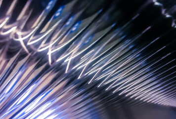 Obraz premium Macro view of shimmering glass surface with repeating patterns and cool blue light, creating a futuristic texture.