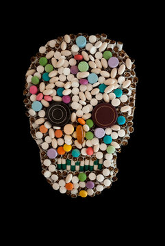 Human skull shape made of various pills and cigarettes on black