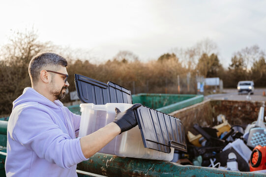 Responsible adult sorting plastic waste at recycling centre.