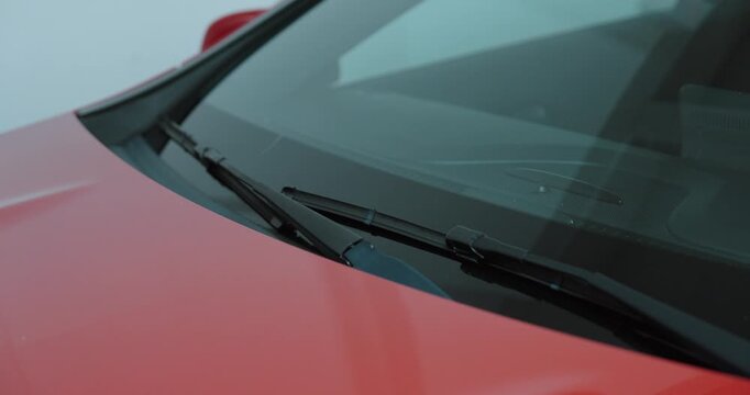 an accident report form placed under a car windshield wiper. Concept of traffic incident documentation, insurance claim process, liability evidence and roadside procedure.