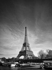 Obraz premium Black and white scene with view from a cruising boat trip along the Seine river to the breathtaking Eiffel Tower. The iconic Parisian landmark as global attraction. French trip symbol