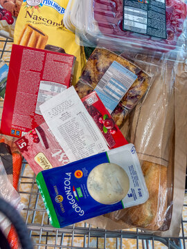 Parndorf, Austria - 18 Oct 2025: view of groceries and a shopping receipt in a shopping cart, featuring Gorgonzola cheese, a baguette, and packaged baked goods