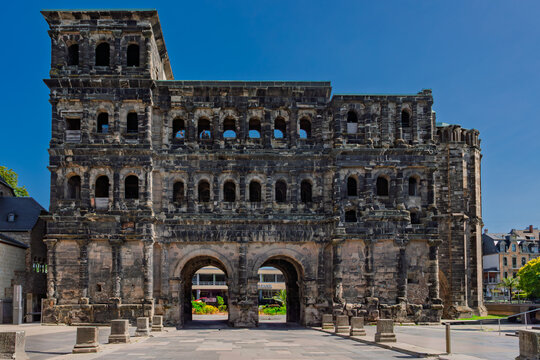 Porta Nigra in Trier, Germany - UNESCO Roman city gate landmark with historic stone facade and arches under a clear blue sky