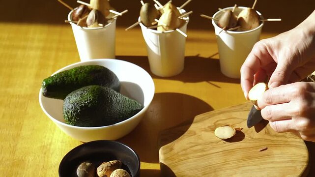 Detailed horizontal footage of hands peeling outer skin from avocado seed. Symbolizes mindful tactile organic routine, intentional lifestyle shift, and nature centered self development practice.