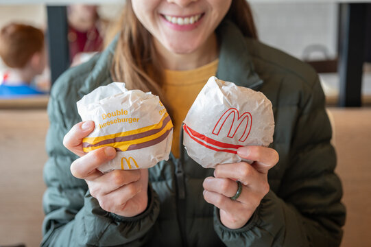 Chiang Rai, Thailand : January-17-2026 : Happiness Asian woman holding McDonald's hamburger in hands before eating in McDonald's restaurant.