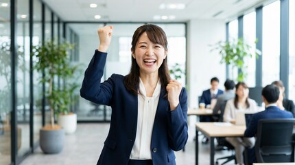 Fototapeta premium Workplace Victory: A determined professional beams with elation, her fist raised in a symbol of personal triumph, standing at the forefront of a modern office environment. 