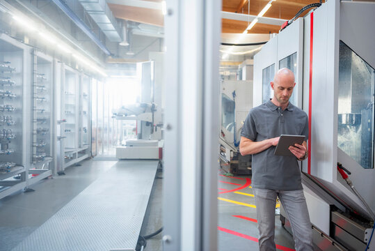 Engineer using tablet in modern industrial factory interior