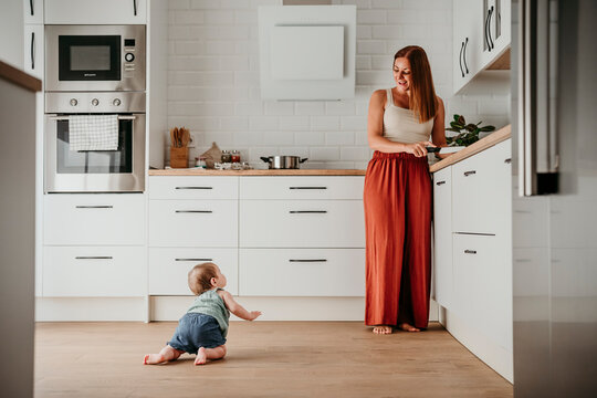 Mother and baby bonding in kitchen at home enjoying quality time
